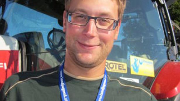 Ein Mann steht vor einem Steyr-Traktor.