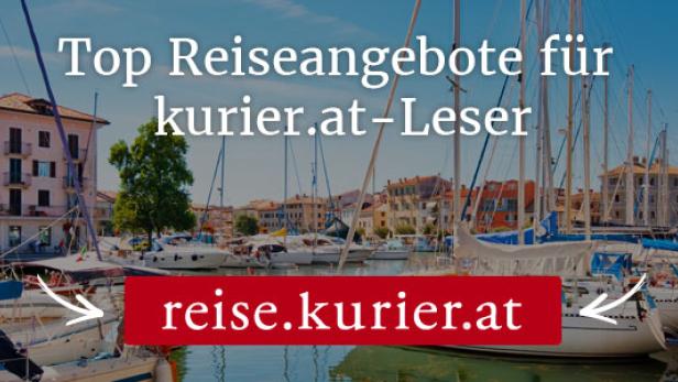 Ein Hafen mit zahlreichen Segelbooten und bunten Häusern im Hintergrund.