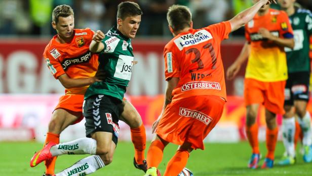 Fußballspieler kämpfen um den Ball während eines Spiels.