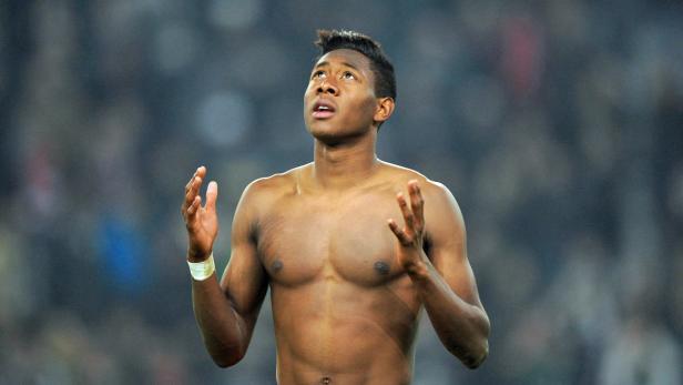 David Alaba jubelt mit freiem Oberkörper auf dem Fußballfeld.