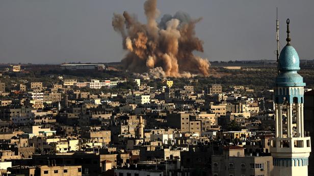 Eine Explosion inmitten einer Stadtlandschaft mit einem Minarett im Vordergrund.