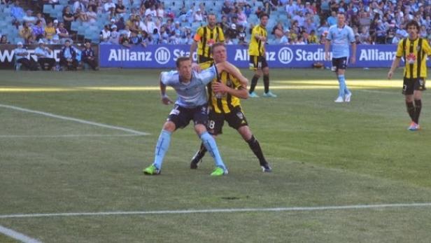 Zwei Fußballspieler kämpfen um den Ball auf dem Spielfeld.