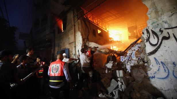 Ein Gebäude steht in Flammen, während Feuerwehrleute versuchen, das Feuer zu löschen.