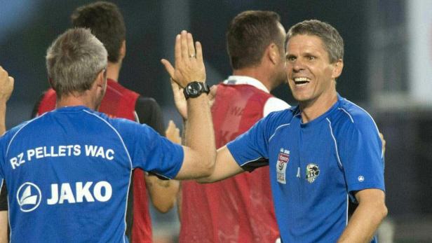 Zwei Männer in blauen Trikots geben sich ein High-Five.