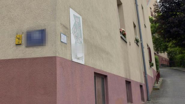 Ein Gebäude mit einem Lageplan und Blumenkästen an den Fenstern.