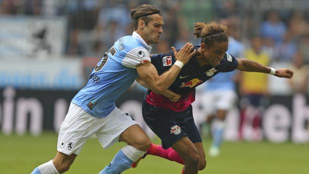 Zwei Fußballspieler kämpfen um den Ball während eines Spiels.