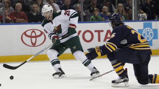 Ein Eishockeyspieler der Minnesota Wild spielt gegen einen Spieler der Buffalo Sabres.