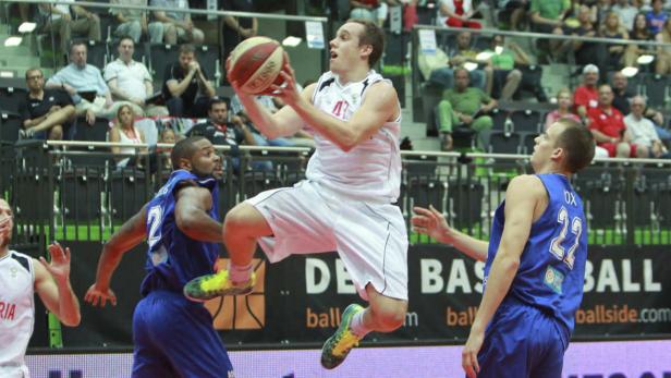 Ein Basketballspieler springt mit dem Ball in der Hand hoch, um einen Korb zu werfen.