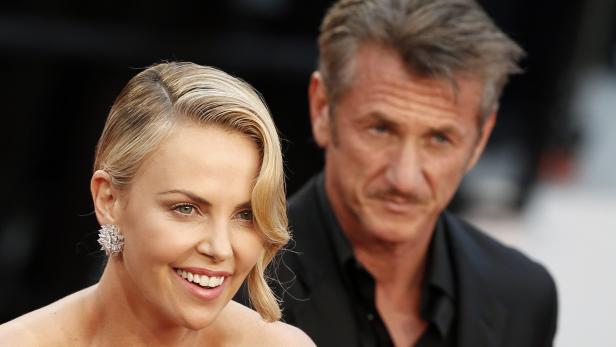 Charlize Theron und Sean Penn posieren auf einem roten Teppich.