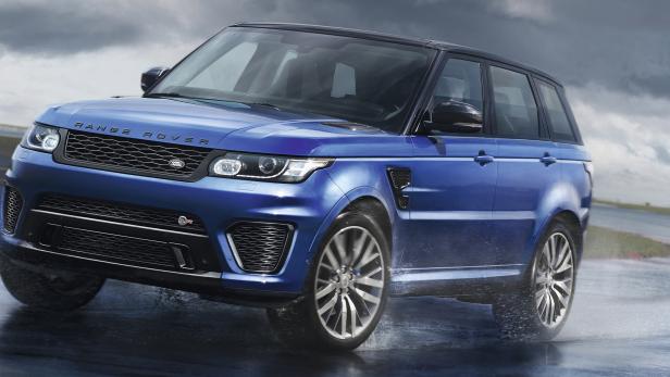 Ein blauer Range Rover Sport fährt auf einer regnerischen Rennstrecke.