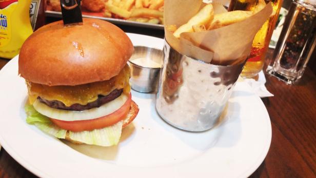Der Big Cheese Burger im Hard Rock Cafe Wien wird mit Pommes und Dip serviert.