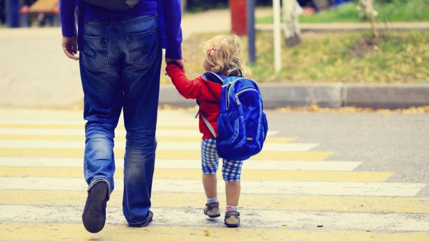 father with little daughter walking to school or d (Symbolbild)