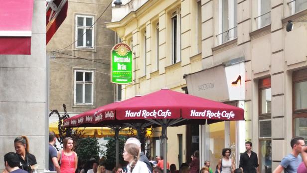 Das Hard Rock Cafe und andere Restaurants beleben eine belebte Straße in Wien.