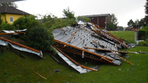 Ein zerstörtes Dach liegt auf einer grünen Wiese.
