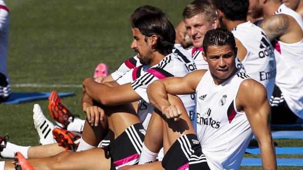 Cristiano Ronaldo und andere Real Madrid Spieler sitzen auf dem Rasen.