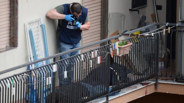 Ein Forensiker fotografiert einen Tatort auf einem Balkon.