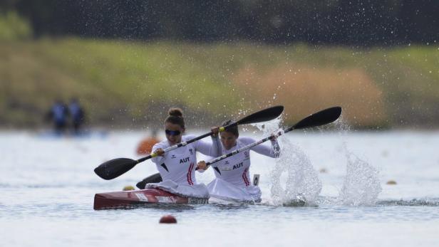 Zwei Kanutinnen des österreichischen Teams paddeln auf einem See.
