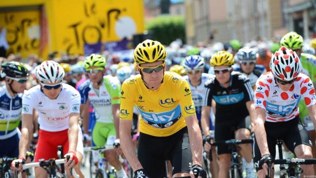 Radfahrer in gelbem Trikot fährt bei der Tour de France mit anderen Fahrern.