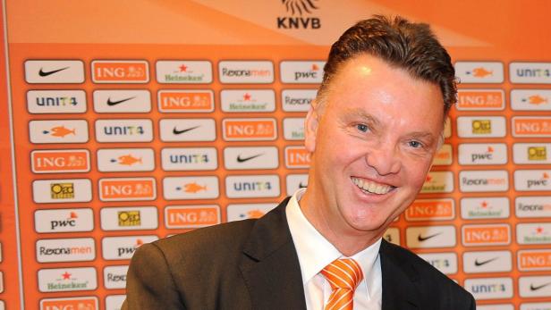 Louis van Gaal lächelt vor einer Wand mit Sponsorenlogos des KNVB.