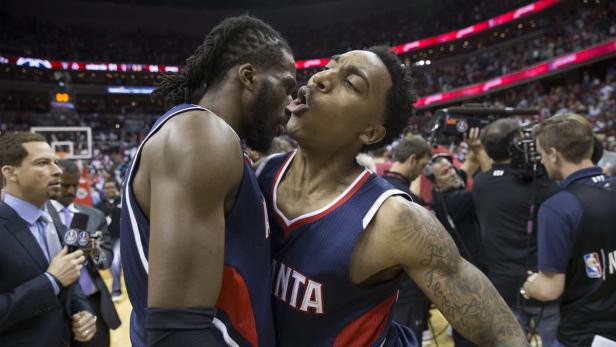Zwei Basketballspieler der Atlanta Hawks stehen eng beieinander auf dem Spielfeld.