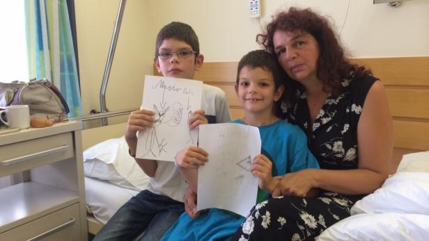 Der neunjährige Fabian und sein verletzter Bruder Daniel mit Mutter Anita Zeilbauer. Das Malen soll helfen, die Attacke zu verarbeiten.