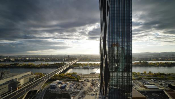 Blick auf Wien mit der Donau und einem modernen Hochhaus im Vordergrund.