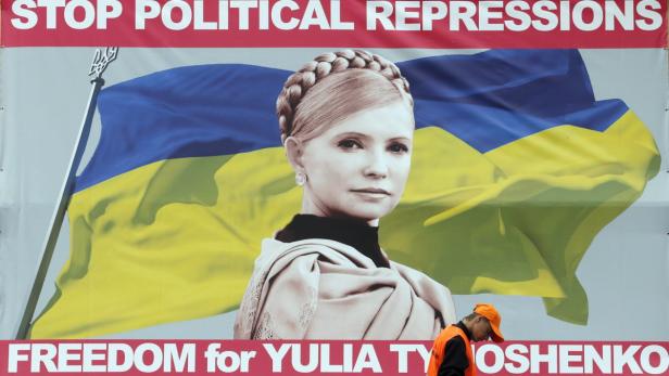 Ein Plakat fordert „Freiheit für Yulia Tymoshenko“ vor der ukrainischen Flagge.