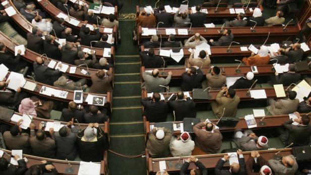 Eine Draufsicht auf eine Parlamentssitzung mit vielen Teilnehmern.