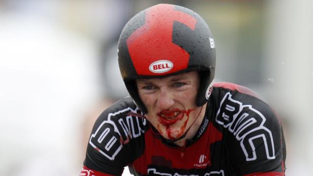 Ein Radrennfahrer mit blutendem Gesicht trägt einen Helm der Marke Bell.