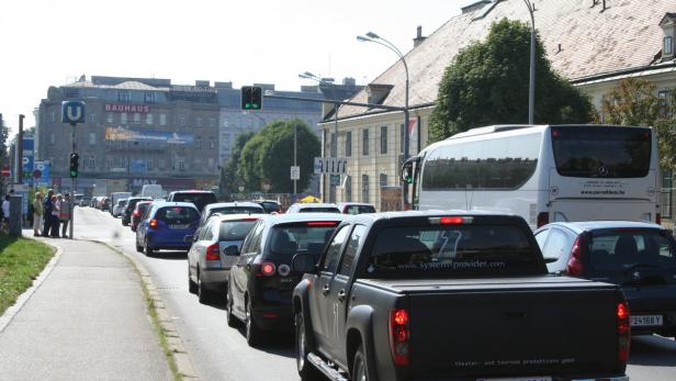 Stau auf einer Straße in Wien vor einem Gebäude mit der Aufschrift „Bauhaus“.