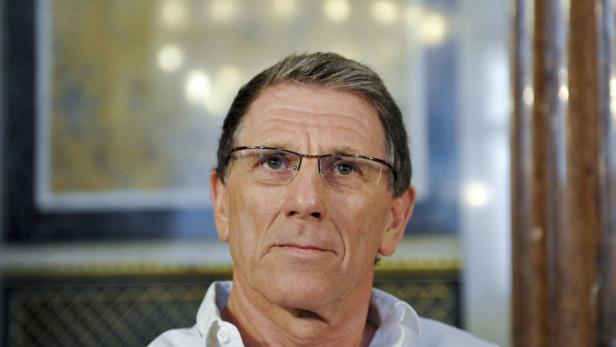 Ein Mann mit Brille blickt aufmerksam nach oben.