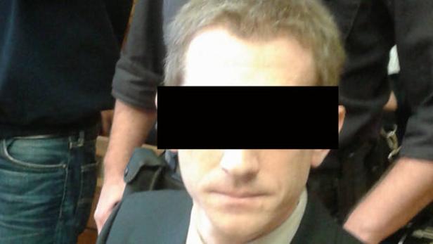 Ein Mann mit verpixelten Gesicht, umgeben von zwei Personen.