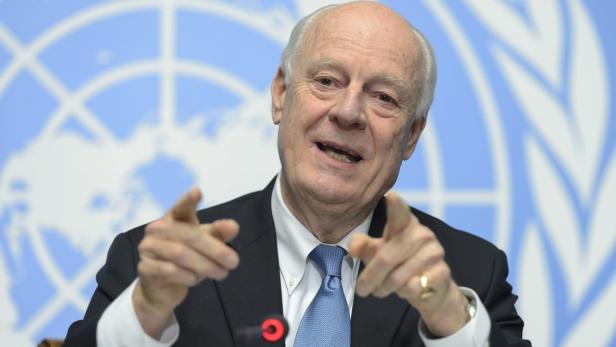 Staffan de Mistura gestikuliert vor einem Hintergrund mit dem UN-Logo.