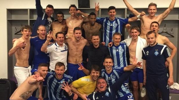 Eine Gruppe Fußballspieler feiert in der Umkleidekabine.