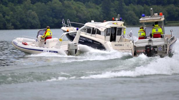 Drei Boote der Wasserrettung sind auf einem See unterwegs.
