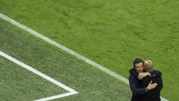 Luis Enrique umarmt einen anderen Mann auf einem Fußballfeld.