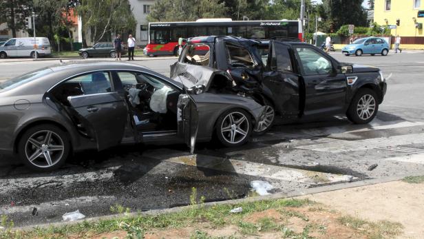 Zwei beschädigte Autos stehen nach einem Unfall auf einer Kreuzung.