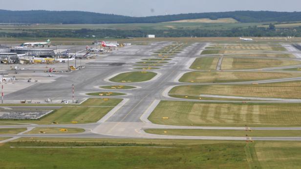 Ein weitläufiger Flughafen mit mehreren Start- und Landebahnen und geparkten Flugzeugen.