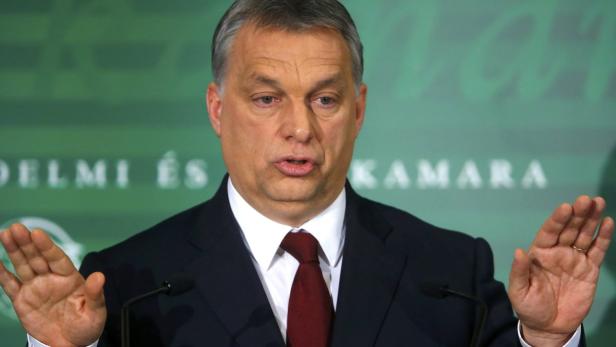 Viktor Orbán gestikuliert während einer Rede vor einem grünen Hintergrund.