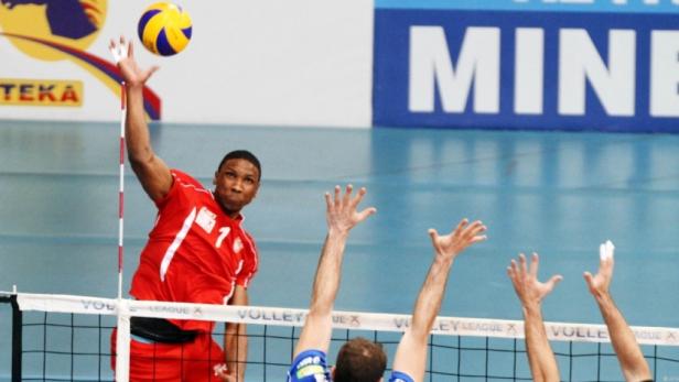 Ein Volleyballspieler schlägt den Ball über das Netz.