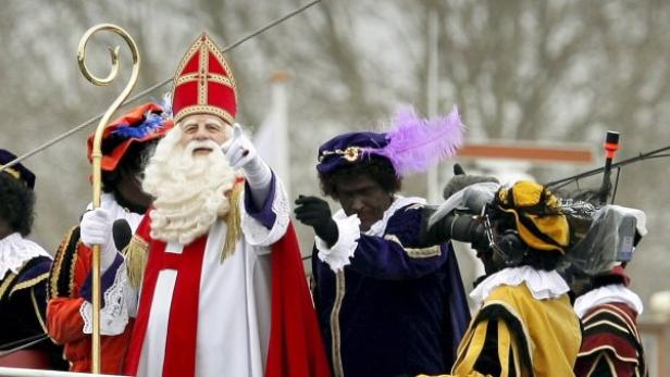 Sinterklaas und seine Helfer, die Zwarte Pieten, winken in die Menge.