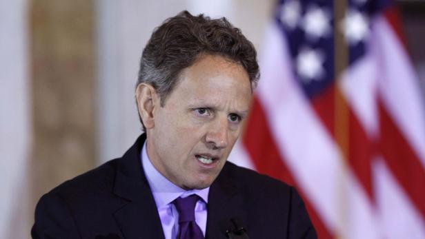 Timothy Geithner spricht vor einer unscharfen US-Flagge.