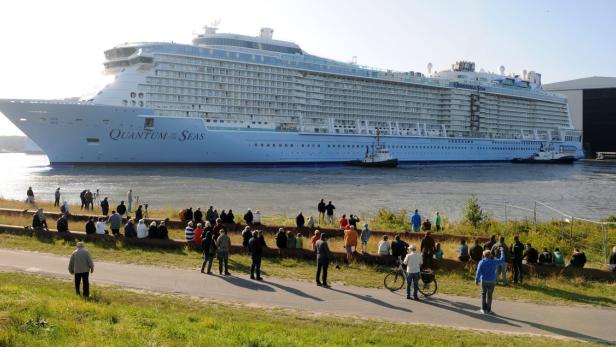 Zahlreiche Menschen beobachten die Ausfahrt des Kreuzfahrtschiffes „Quantum of the Seas“.