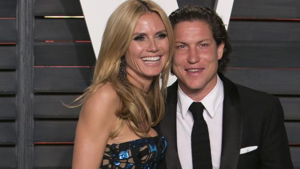 Heidi Klum und Tom Kaulitz posieren lächelnd auf einem Event.