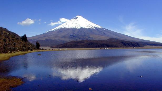 Der schneebedeckte Vulkan Imbabura spiegelt sich in einem ruhigen See.