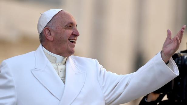 Papst Franziskus lächelt und winkt.