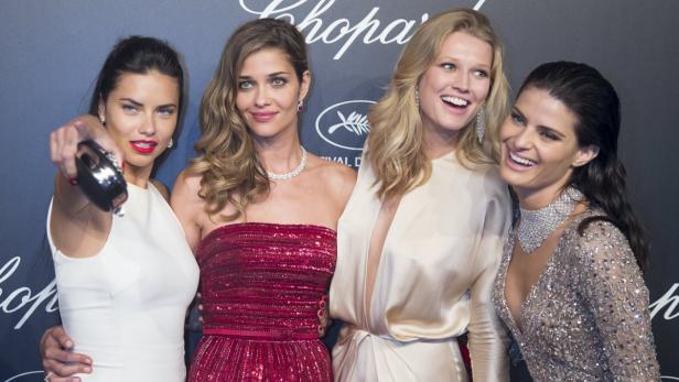 Vier Frauen posieren auf einer Veranstaltung vor einer Chopard-Wand.