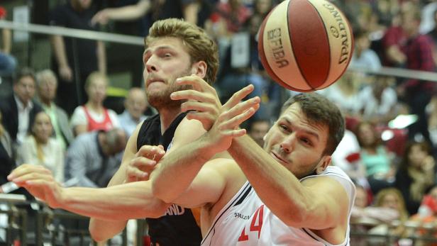 Zwei Basketballspieler kämpfen um den Ball während eines Spiels.