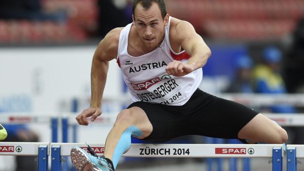 Ein österreichischer Athlet überquert eine Hürde bei einem Leichtathletikwettkampf.