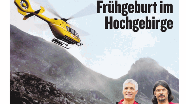 Ein gelber Rettungshubschrauber fliegt über eine Berglandschaft.